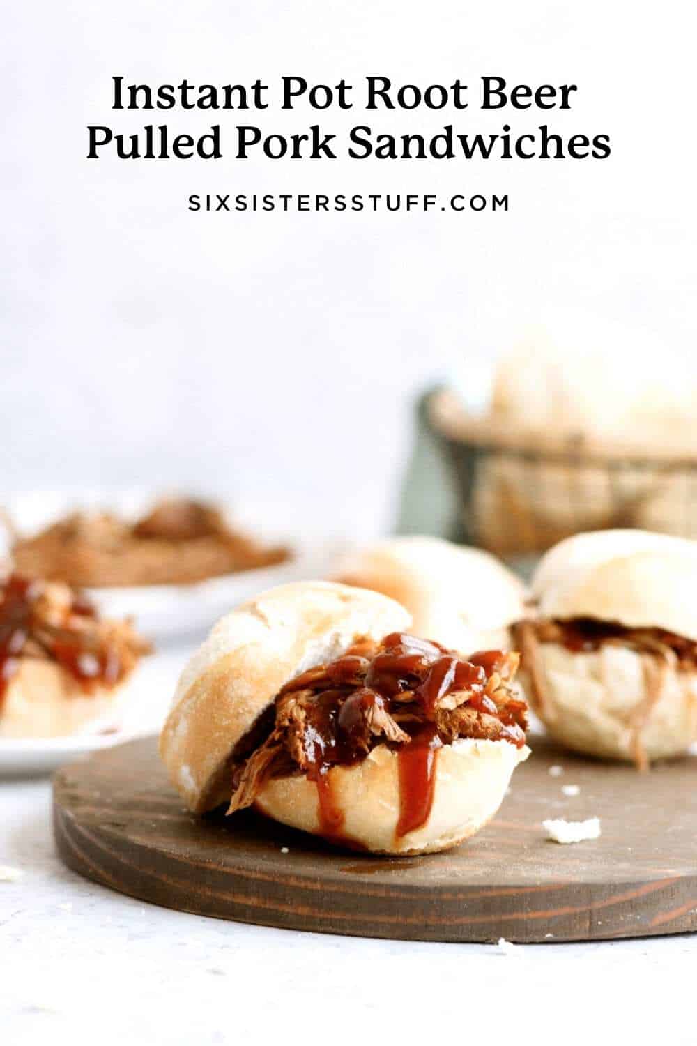 root beer pulled pork sandwiches made in the instant pot on a wooden serving tray with bbq sauce on top