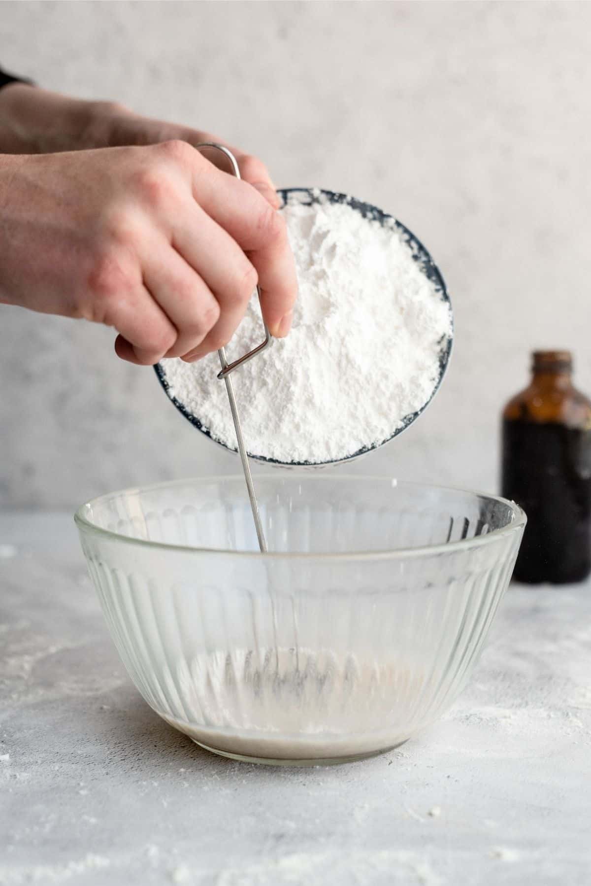 Mixing powdered sugar in glass bowl for donut glaze