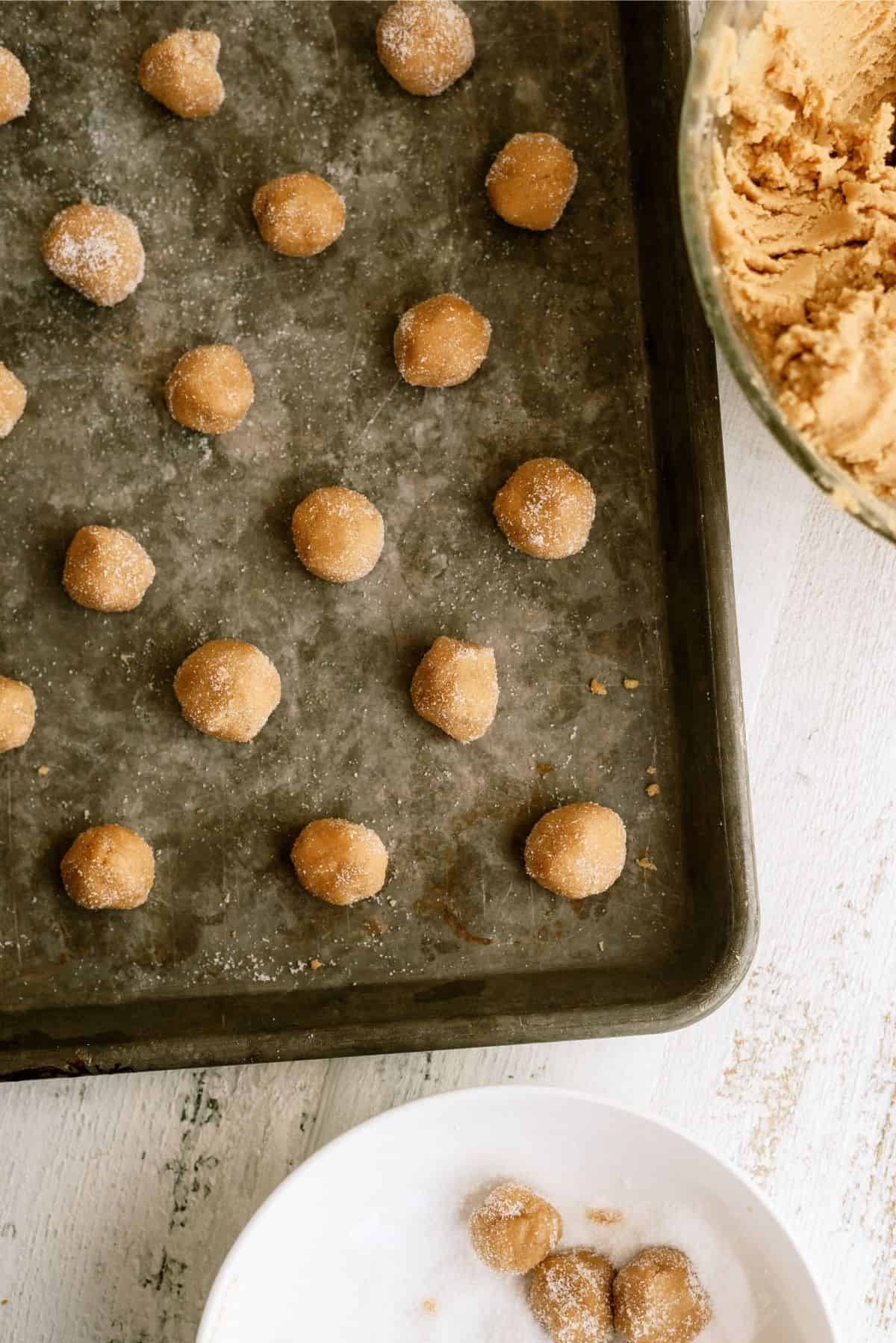 Peanut butter cookie dough rolled into balls on cookie sheet