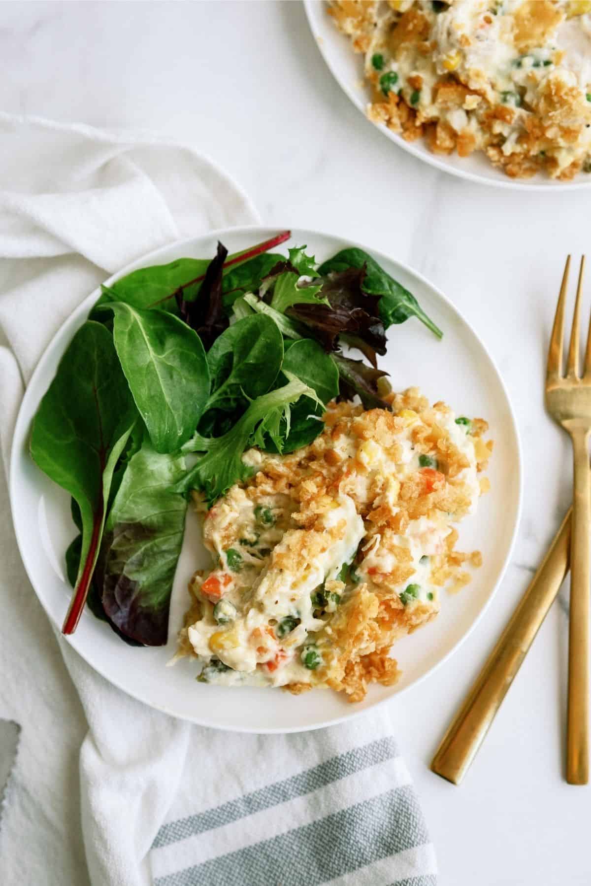 Ritz Cracker Chicken Casserole on a white plate served with salad