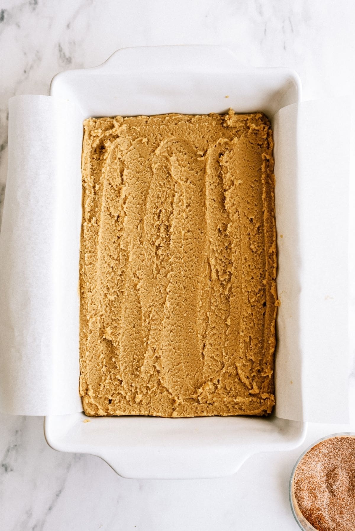 Unbaked Snickerdoodle Blondies pressed into pan