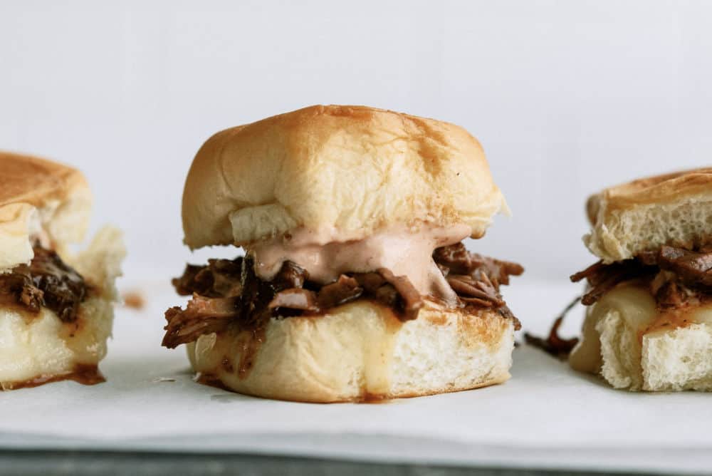 Pot roast sandwiches on a white serving platter