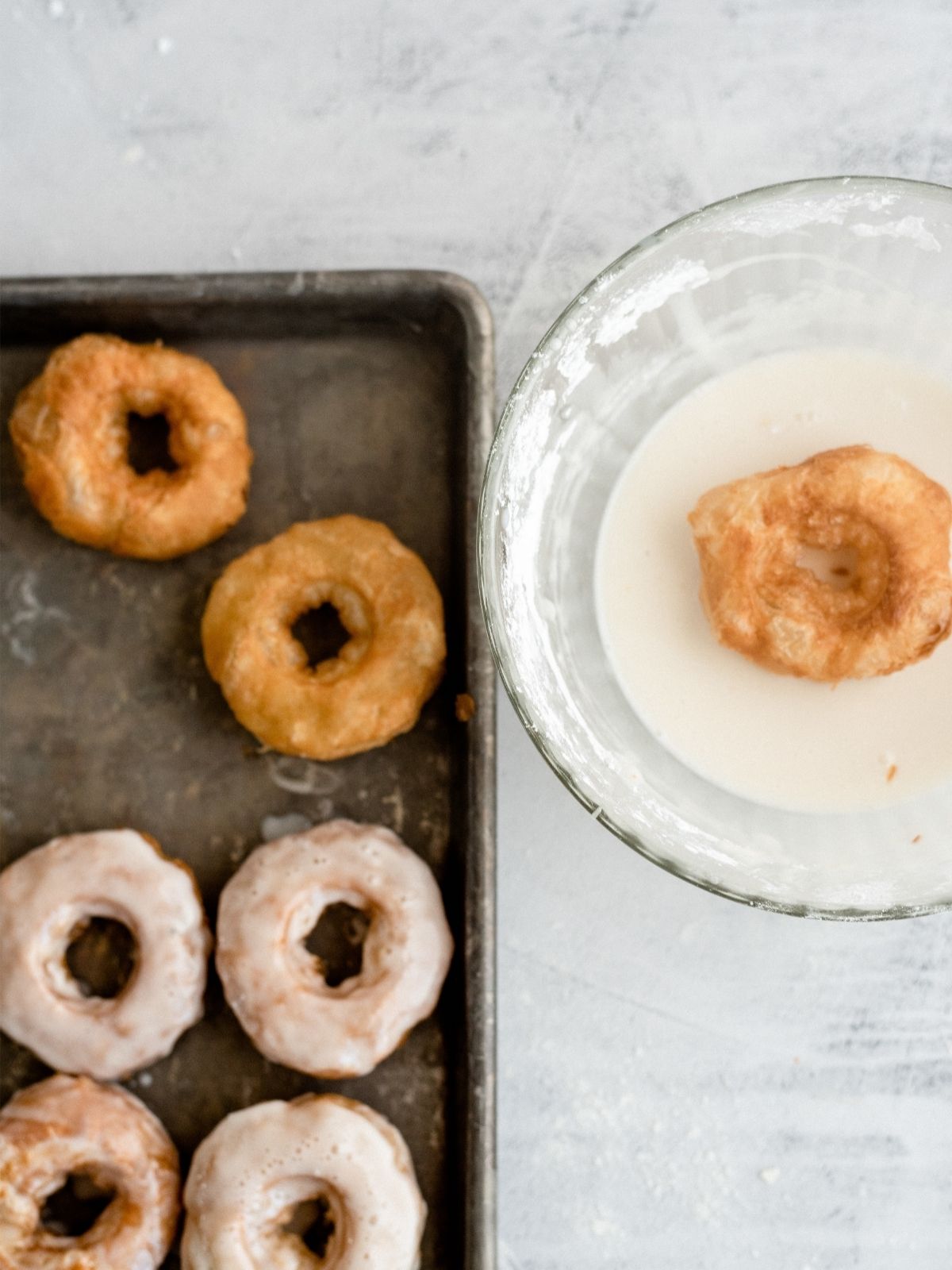 unglazed donuts and glazed donuts on baking sheets
