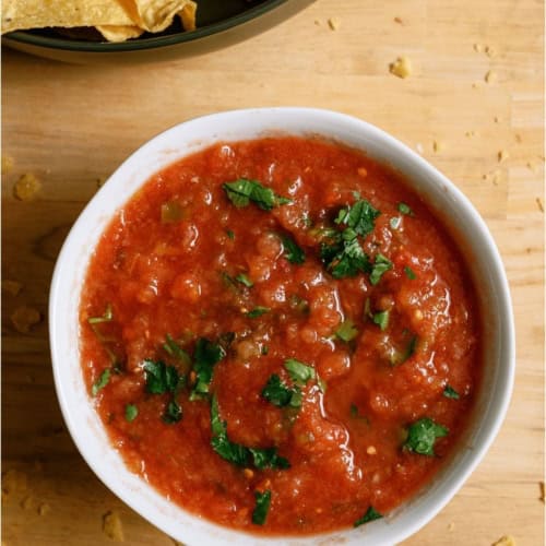 A bowl of Chili's Copycat Salsa with another bowl of chips on the side.