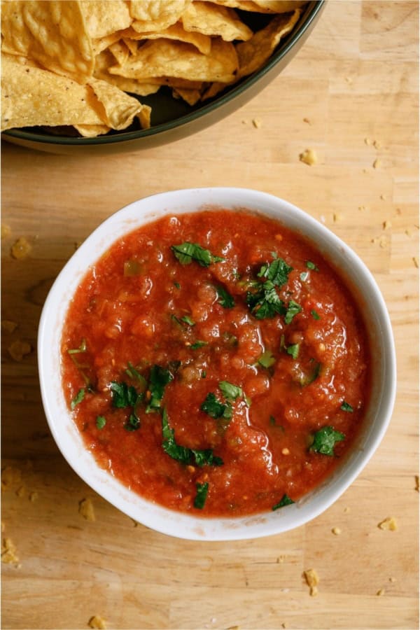 A bowl of Chili's Copycat Salsa with another bowl of chips on the side.