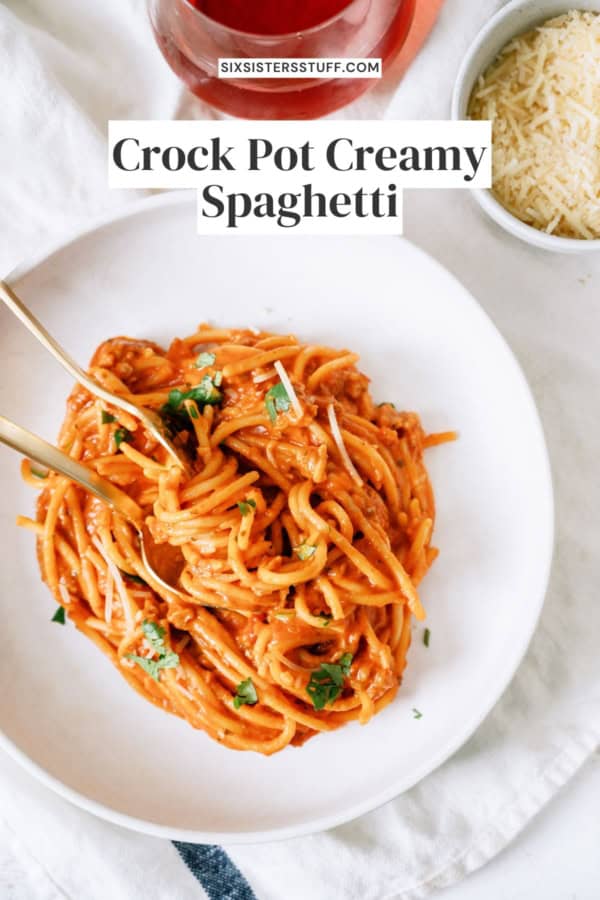A serving of Crock Pot Creamy Spaghetti on a white plate with a fork.