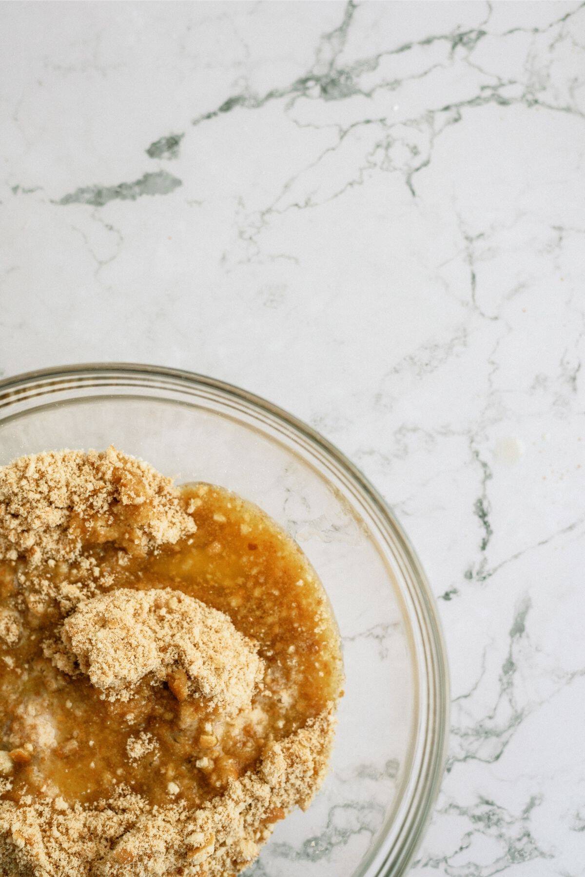 Vanilla Wafer crumbs and butter combined in a glass bowl