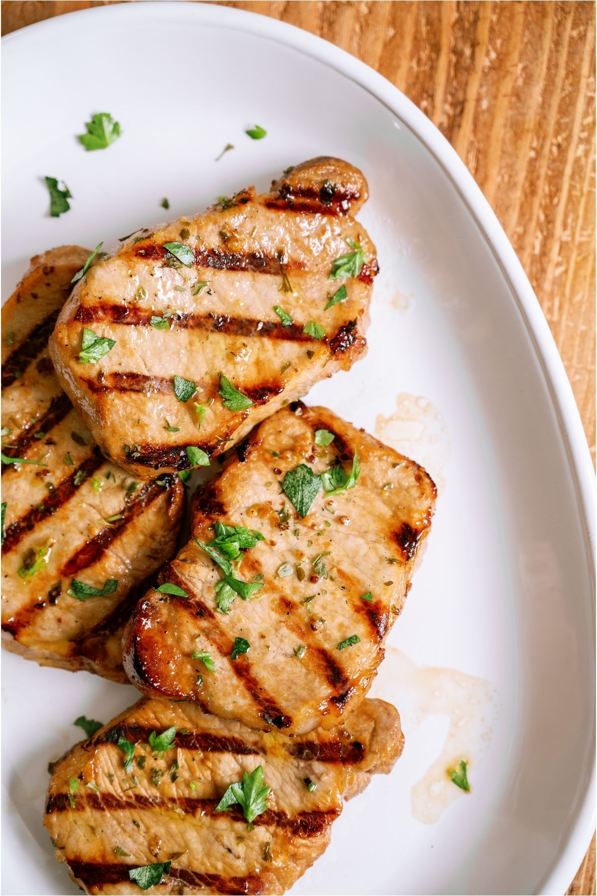 Top view of Marinated Grilled Pork Chops on a white plate.