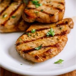 Marinated Grilled Pork Chops on a white plate.