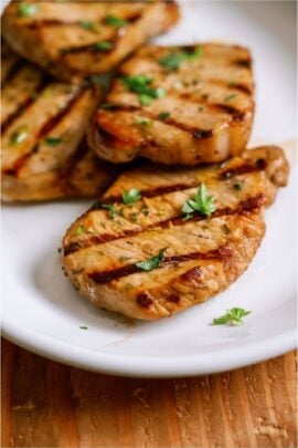 Marinated Grilled Pork Chops on a white plate.