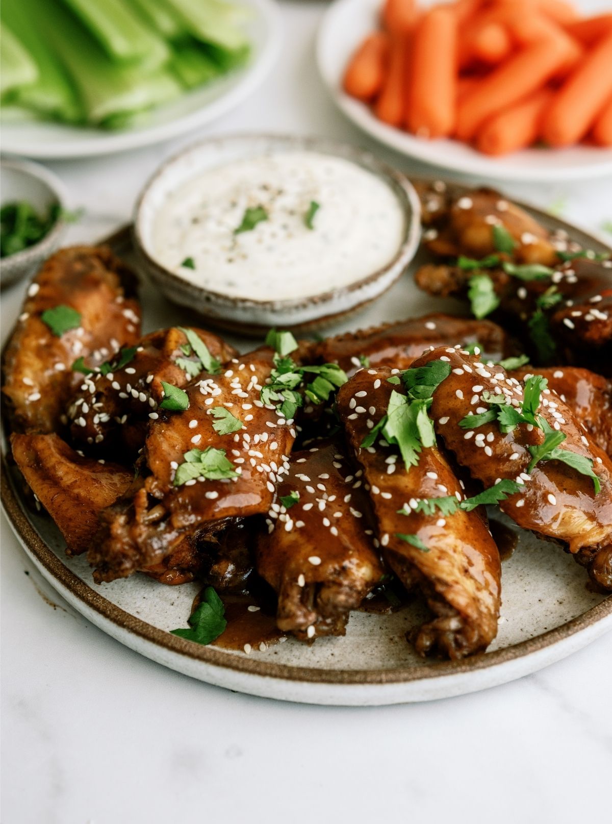 Slow Cooker Sticky Wings  on a plate with dip