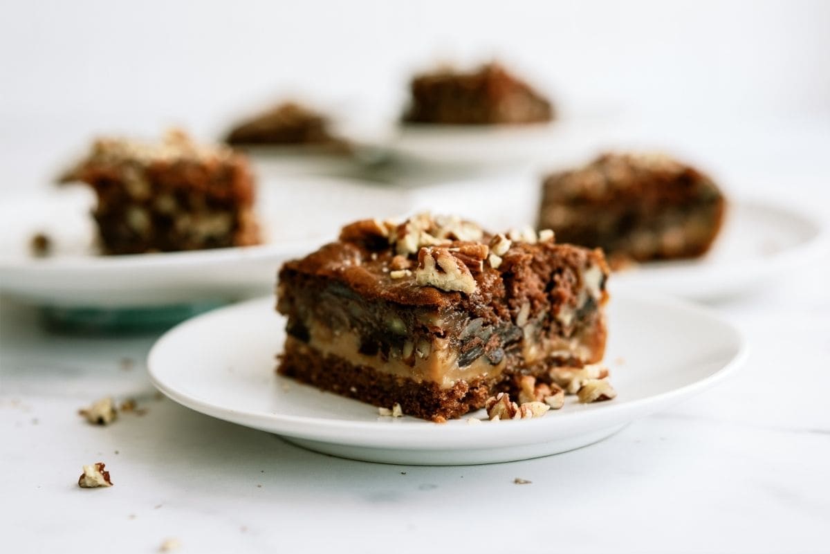 Snickers Cake (Gooey Caramel Chocolate Cake) Recipe on a white plate