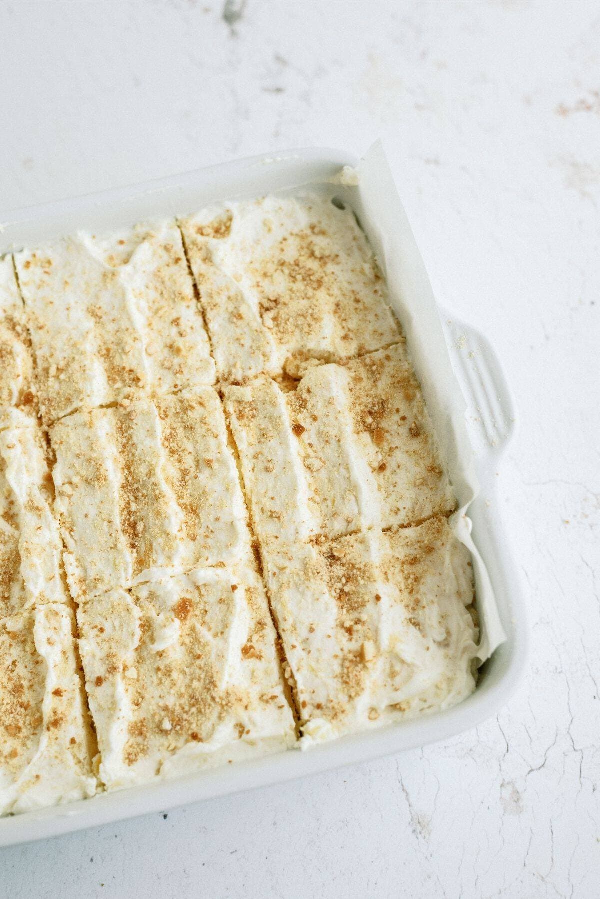 Fluffy Cream Cheese Dessert in baking dish cut into squares.