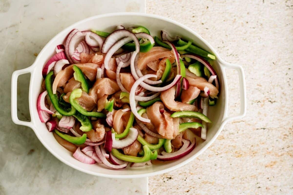 Uncooked Chicken and Chopped Veggies in Casserole dish