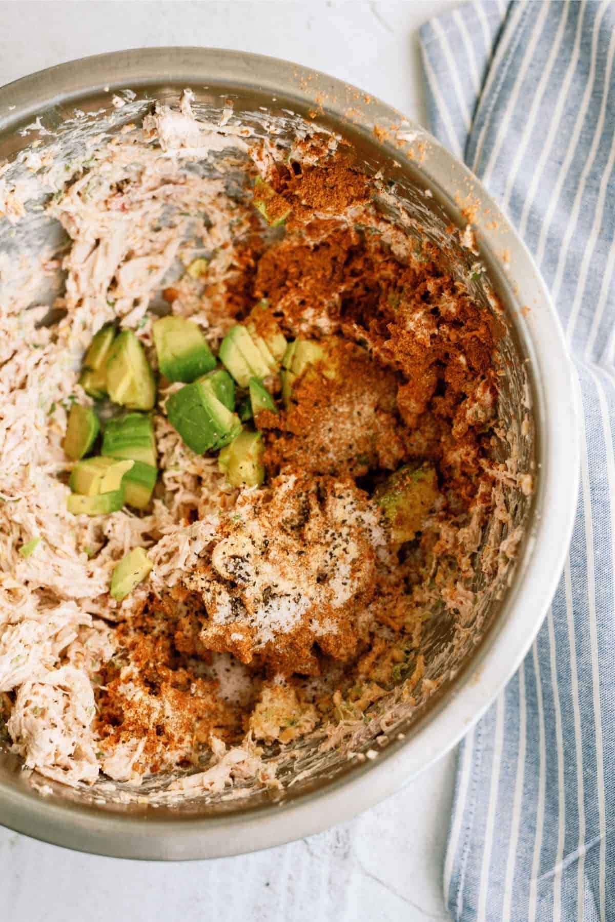 Chicken taco ingredients mixed together in metal bowl