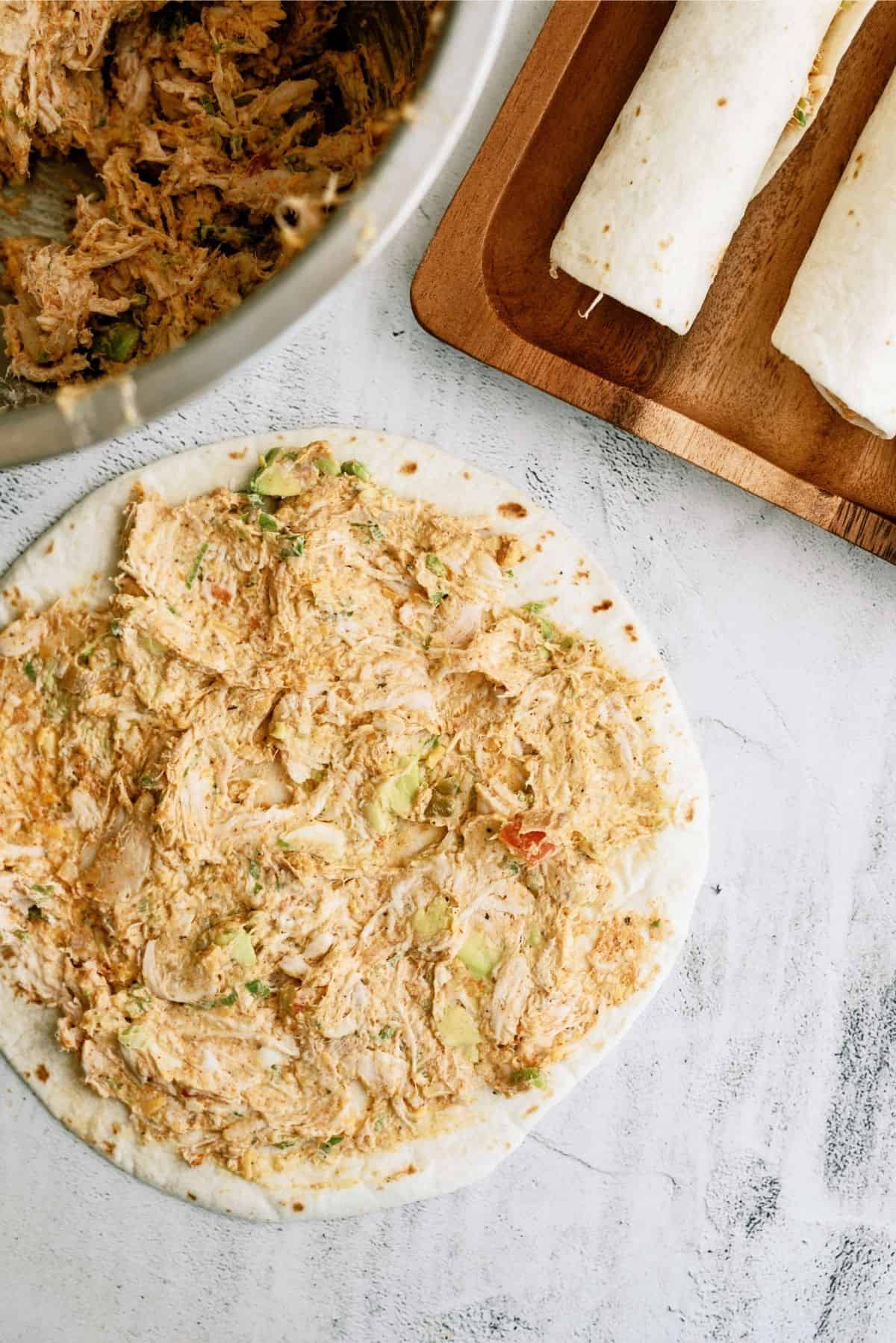 Thin layer of cream chicken mixture spread on tortilla