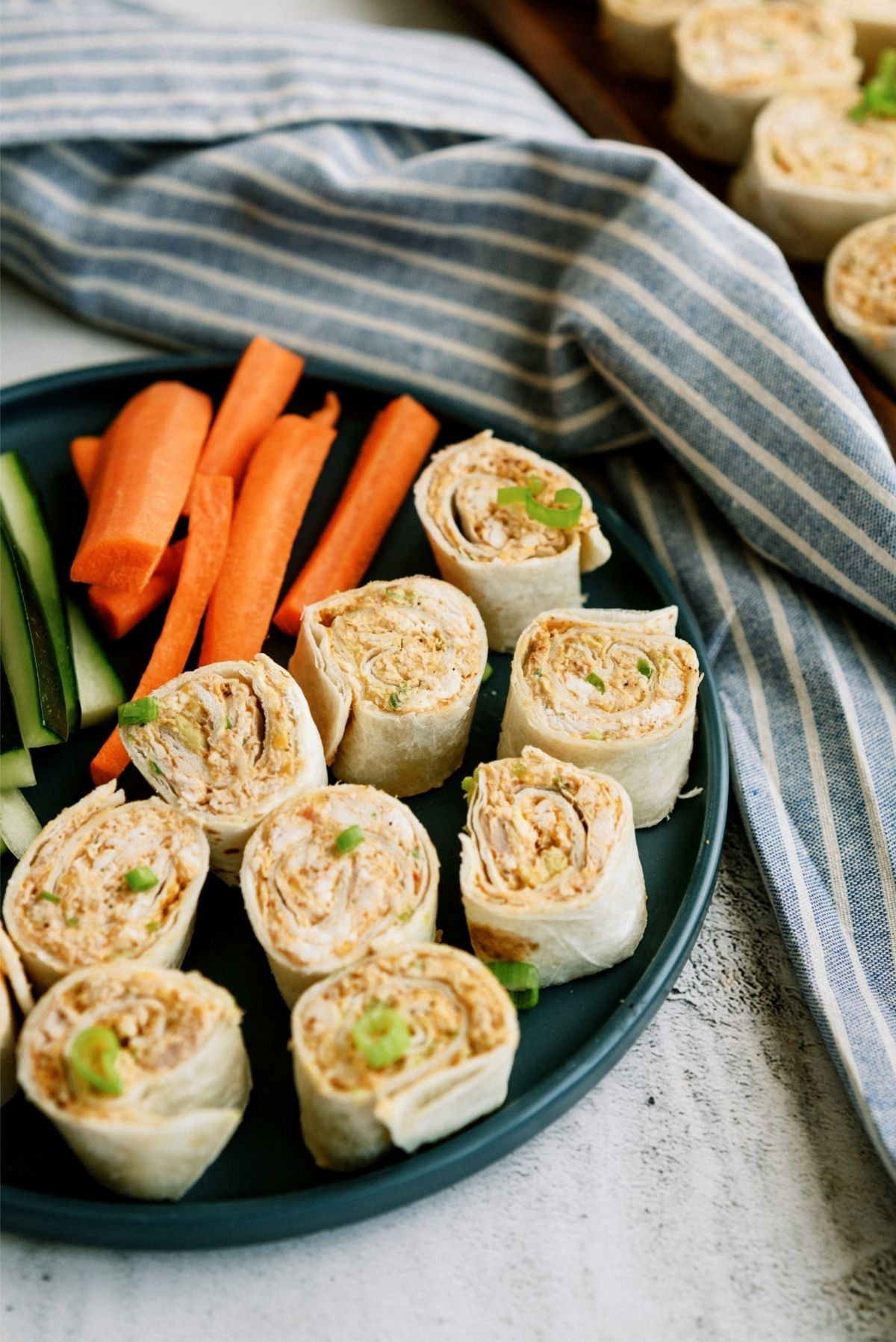 Chicken Taco Roll Ups on a plate served with carrots and celery