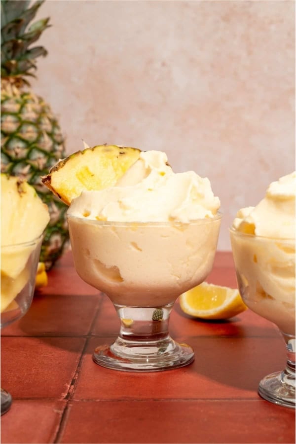 Disneyland Dole Whips in glasses garnished with slices of pineapple.