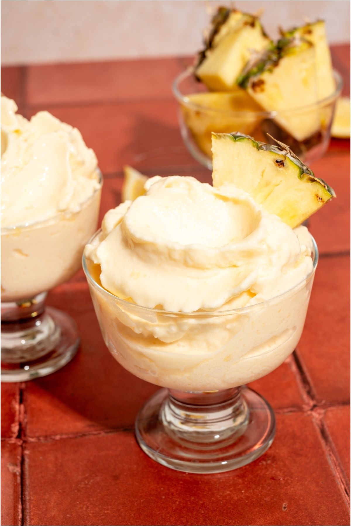 2 glasses of Disneyland Dole Whips topped with slices of pineapple.