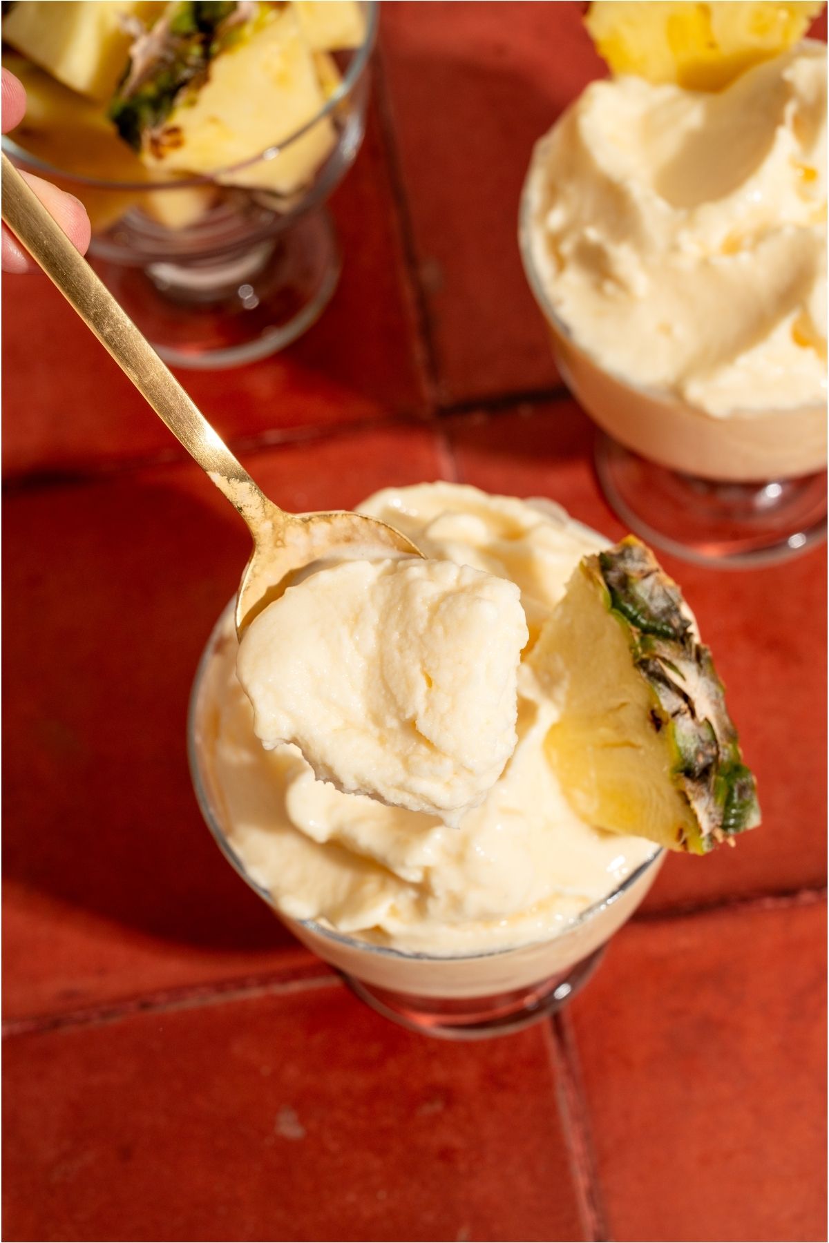 Top view of a spoon lifting out a bite of Disneyland Dole Whip out of a glass.