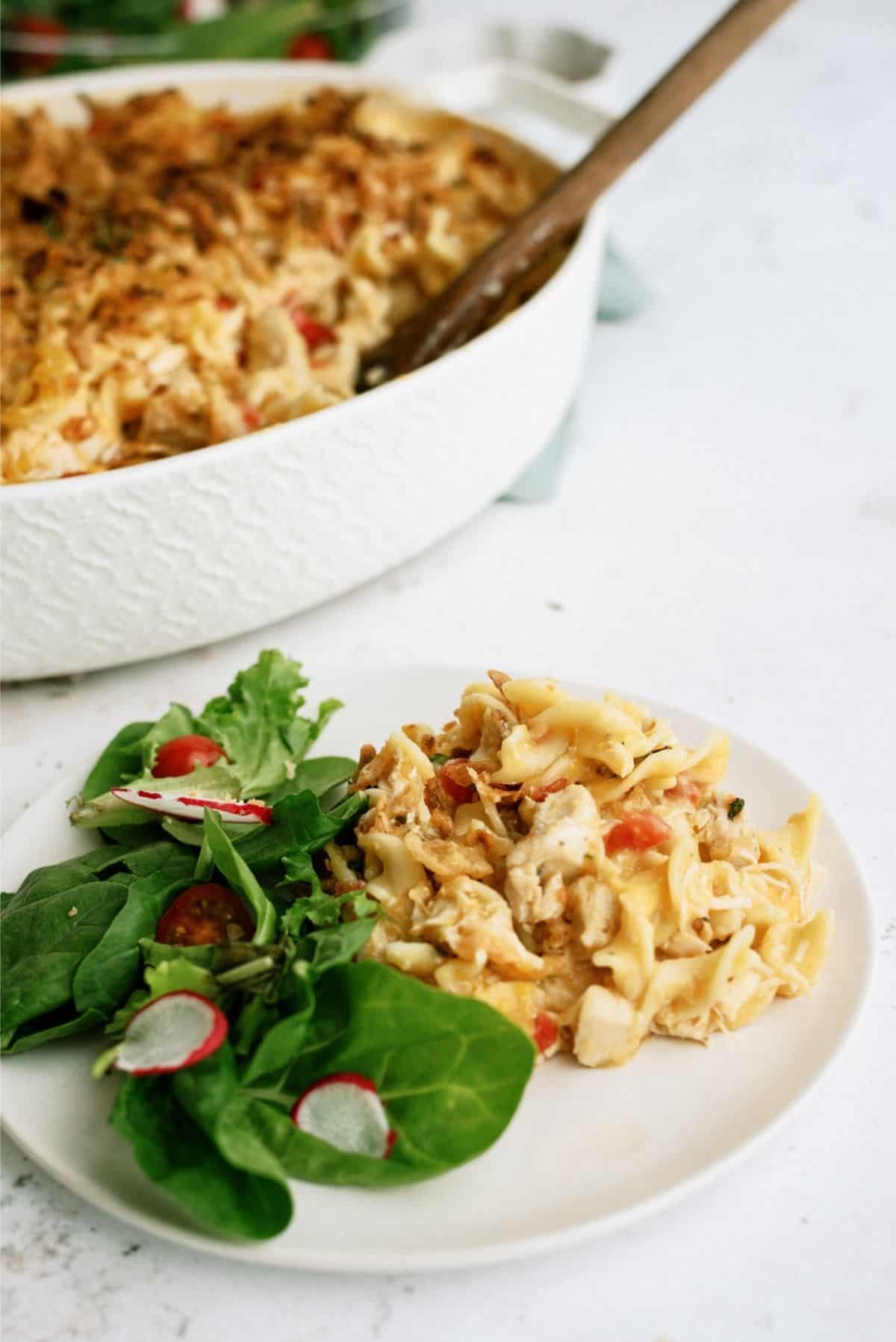French Onion Chicken Noodle Casserole on a plate with a side salad