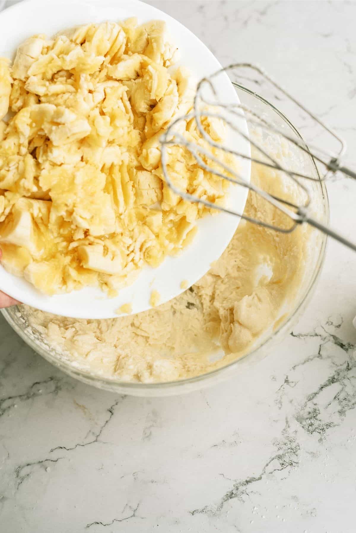 Adding mashed bananas to sugar and butter mixture