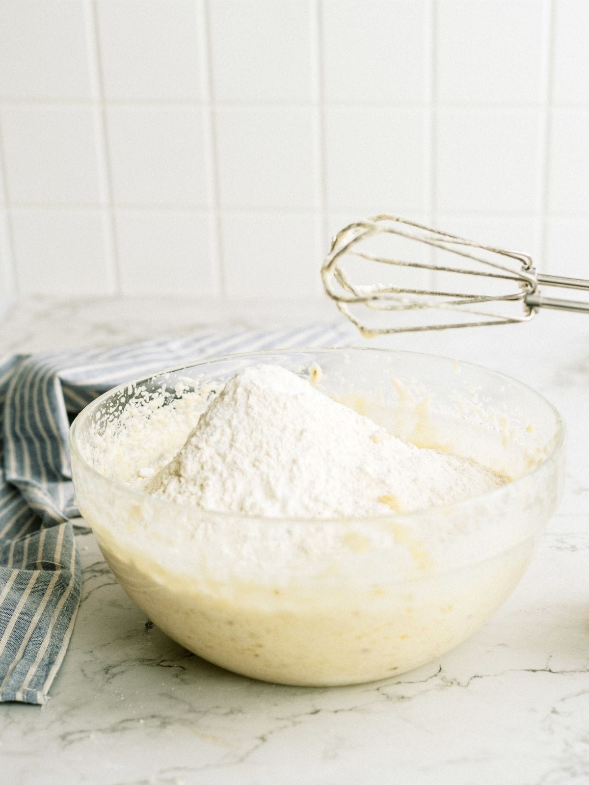 Adding dry ingredients to wet ingredients in glass bowl