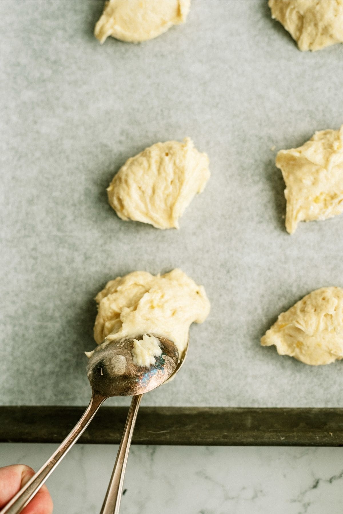 Dropping Cookie batter on baking sheet using table spoons