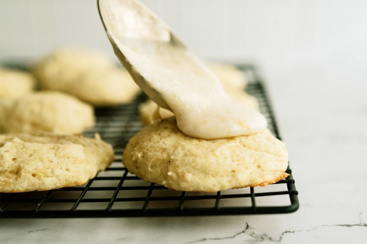 Putting frosting on Banana cookies with a spoon