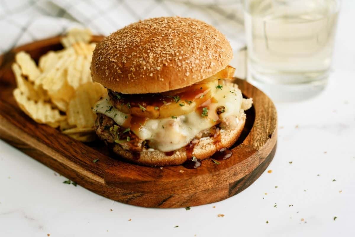 Hawaiian Turkey Burger on a wooden plate with chips