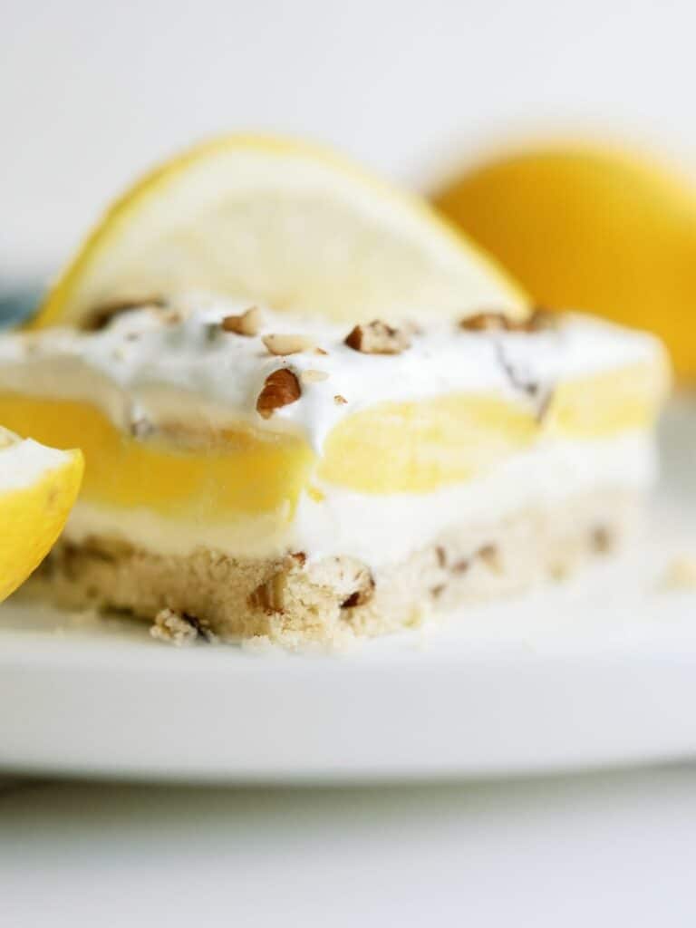Close up of a slice of Layered Lemon Dessert on a plate. 