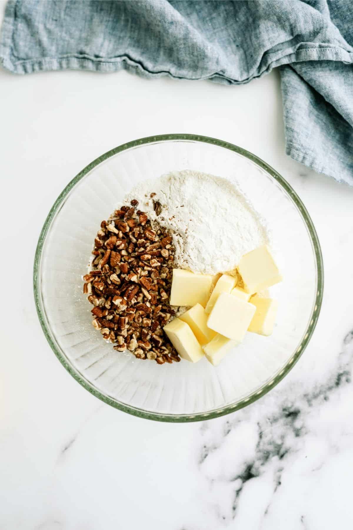medium-sized mixing bowl with flour, ½ of the chopped pecans, and the softened butter