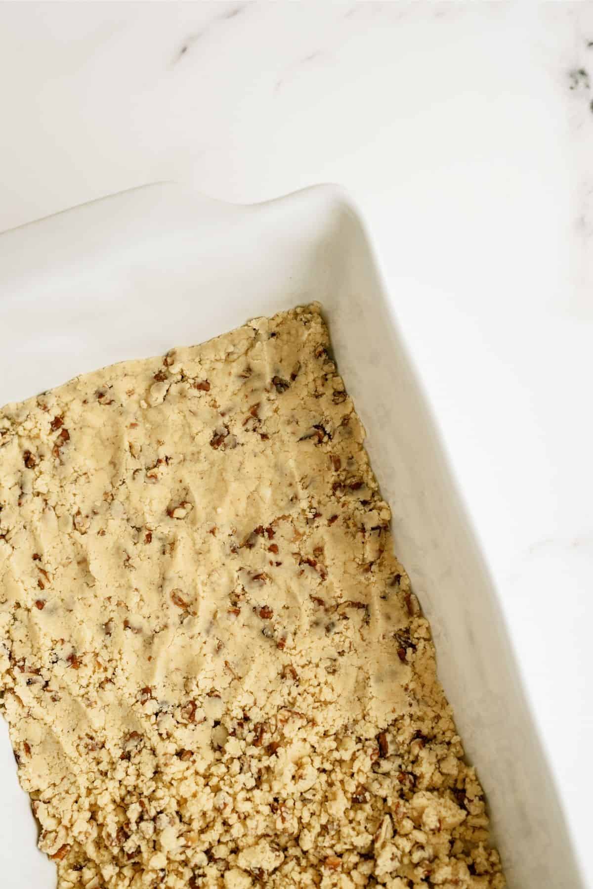 Pecan and flour mix pressed into a baking dish