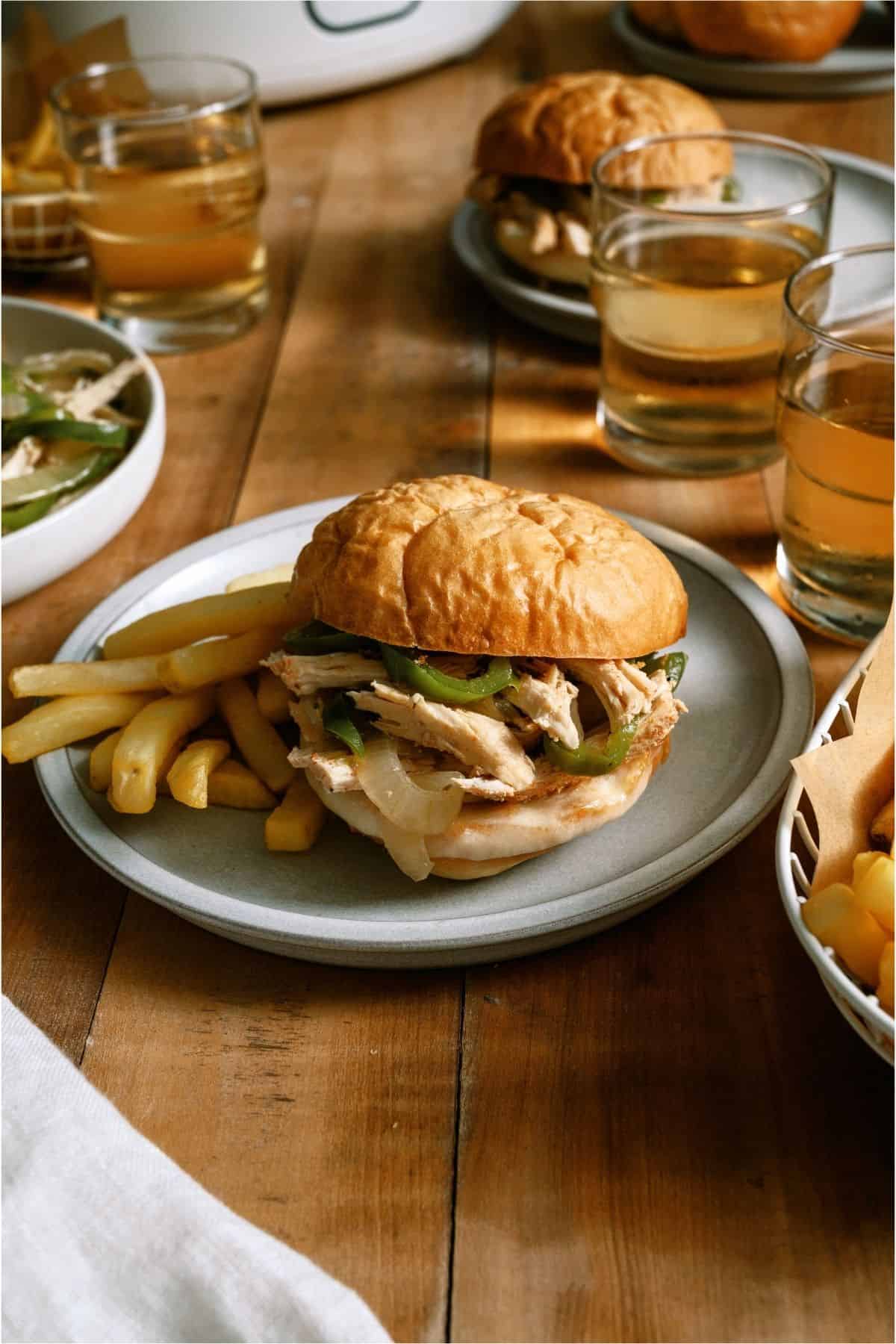 Slow Cooker Chicken Philly Cheesesteaks Sandwich on a plate with fries.