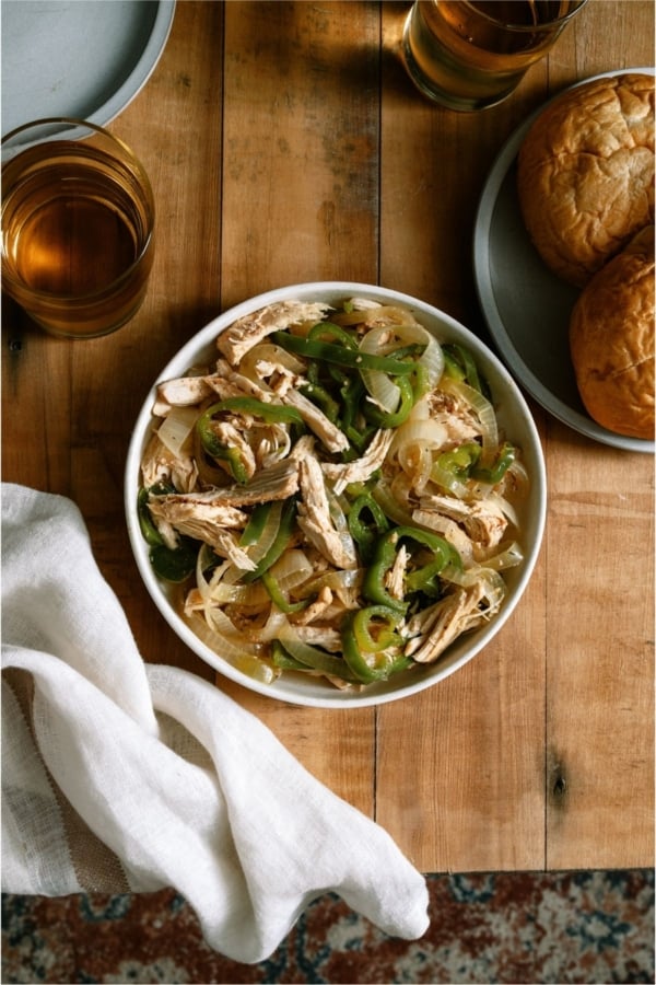 A bowl of Slow Cooker Chicken Philly Cheesesteak meat on a wooden background.