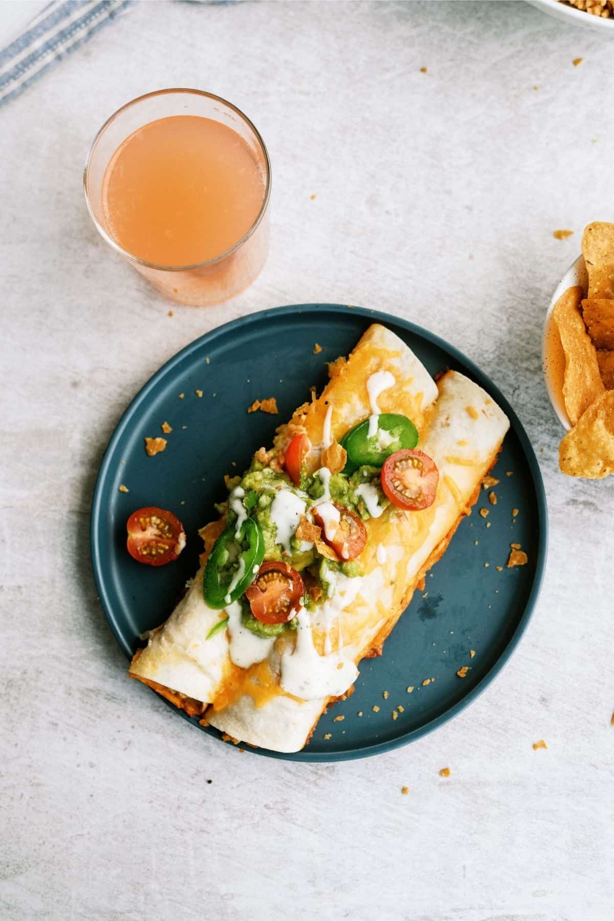 Slow Cooker Ranch Chicken Enchiladas on blue plate with a drink