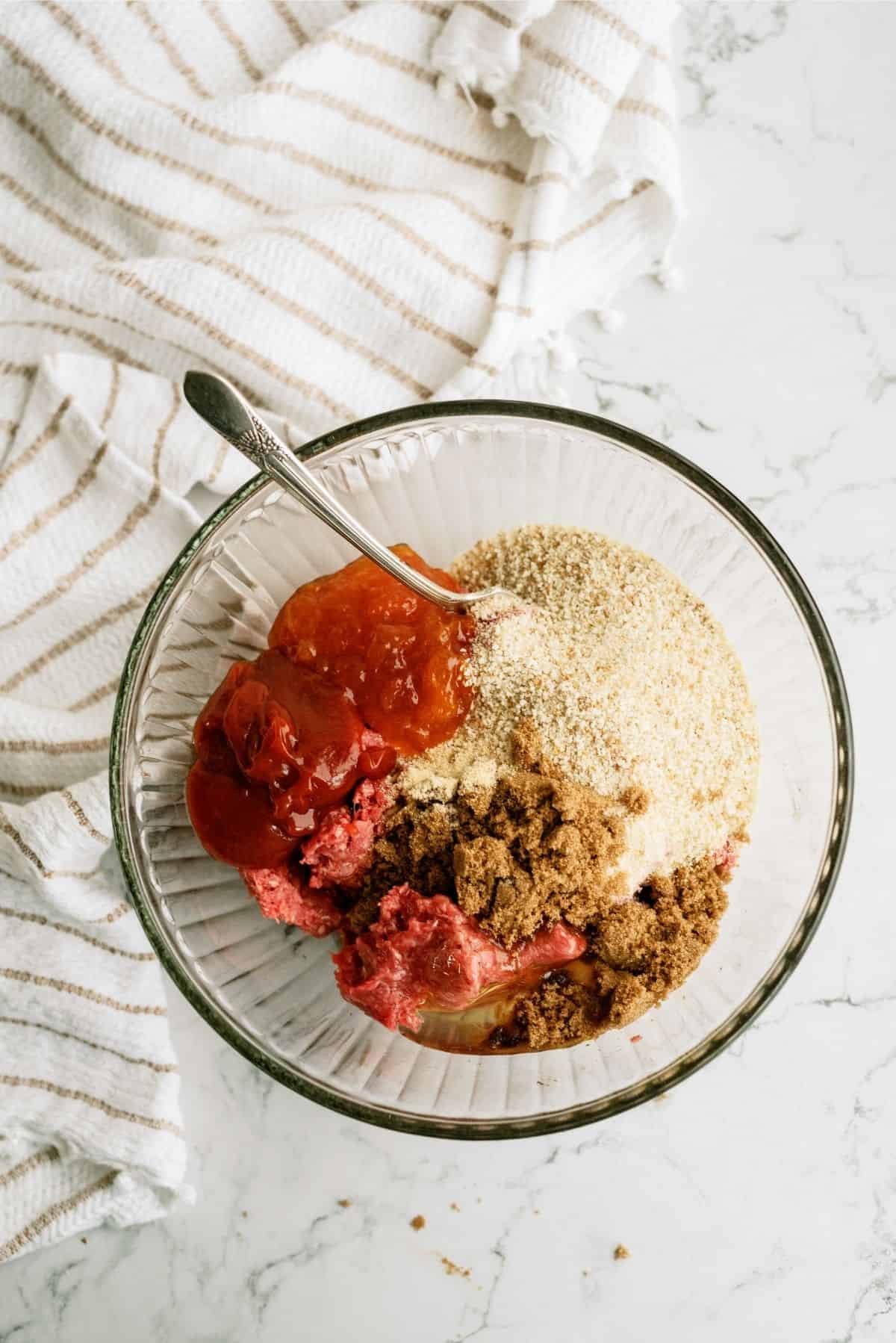 Meatloaf ingredients in a glass mixing bowl