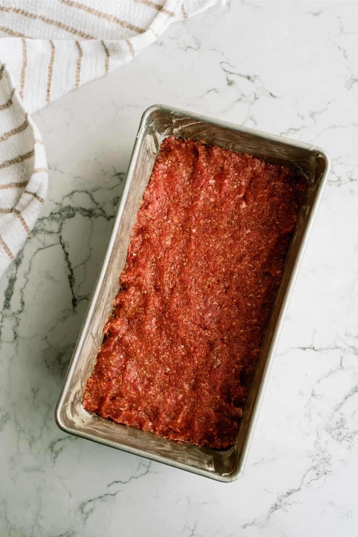 Meatloaf mixture pressed into a loaf pan