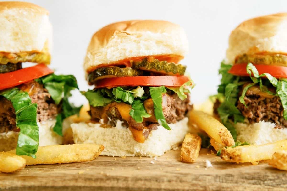 3 Baked Cheeseburger Sliders in a row with fries