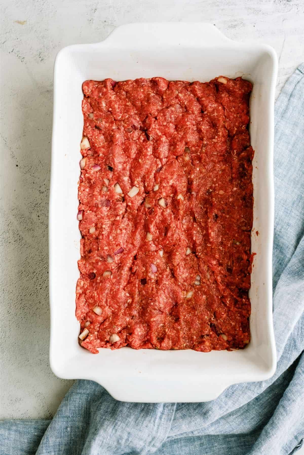 Raw Hamburger Mixture pressed into a 9x13 pan