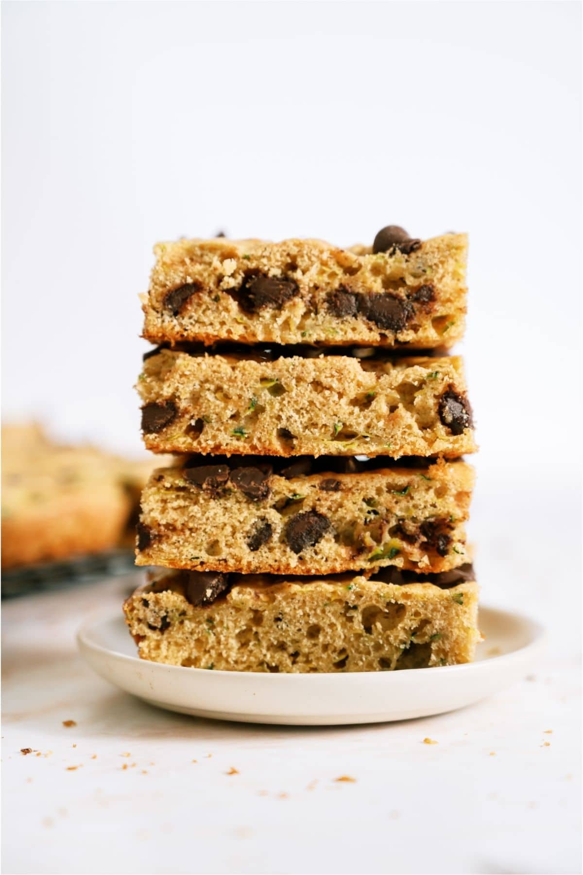 4 Chocolate Chip Zucchini Bars stacked on a plate.