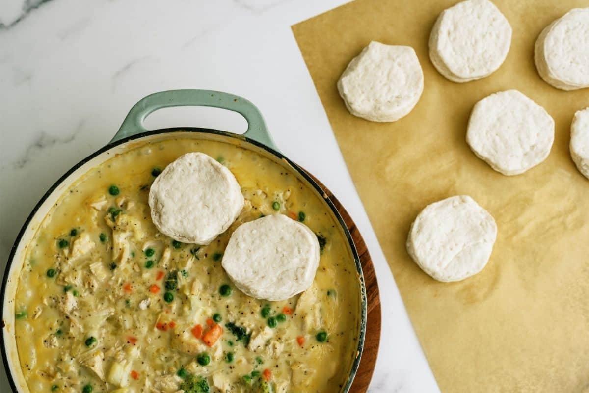 Placing uncooked biscuits on top of Pot Pie mixture