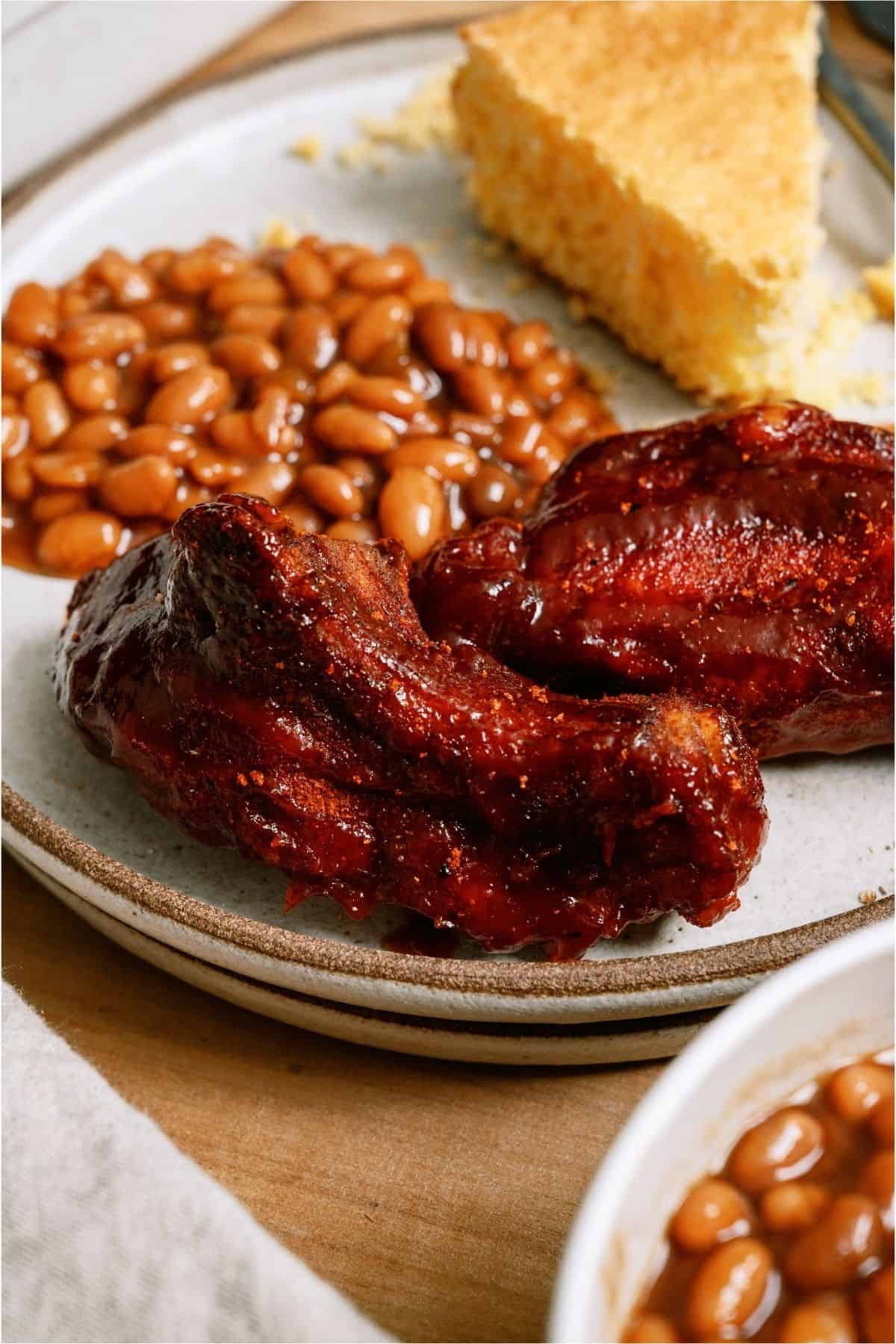 Instant Pot BBQ Country Ribs on a plate with beans and cornbread.