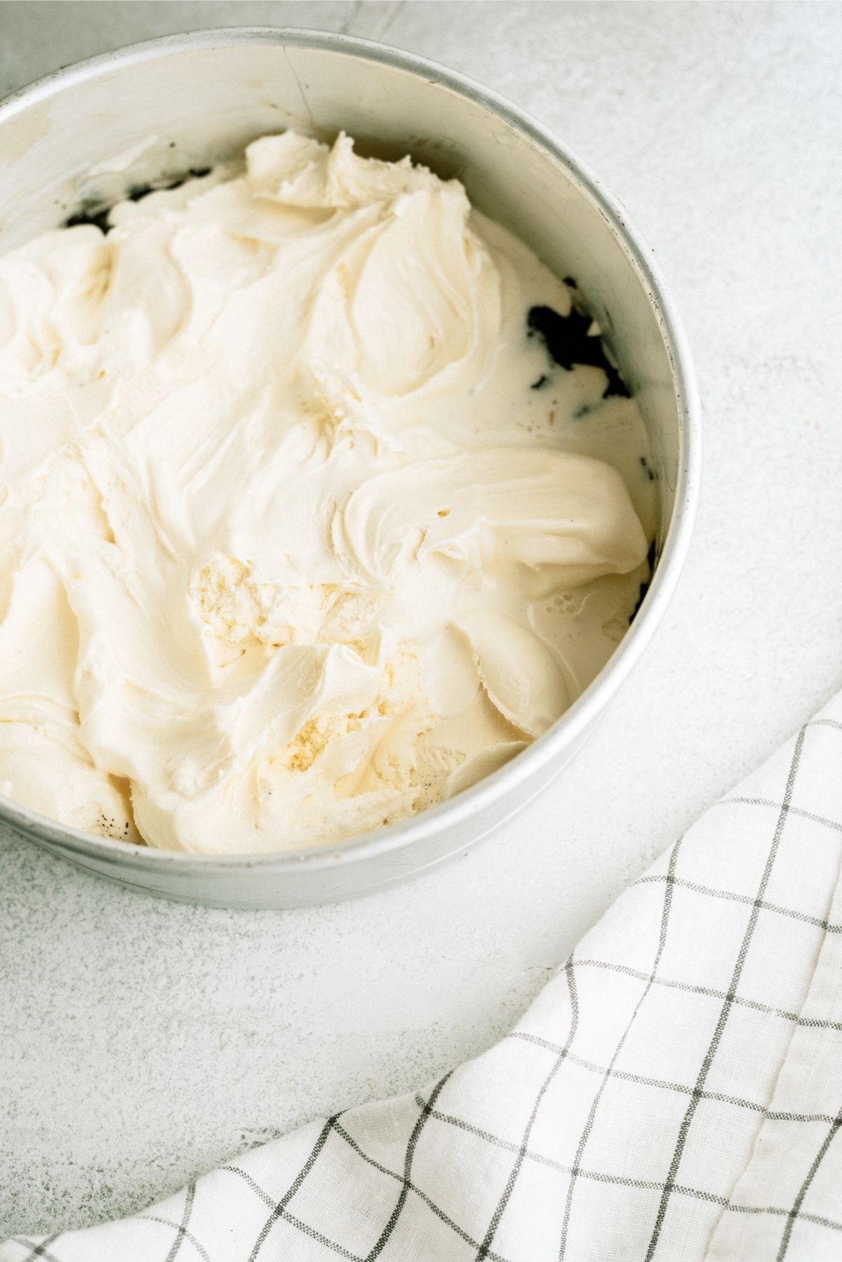 Softened Vanilla Ice Cream spread over crushed oreos