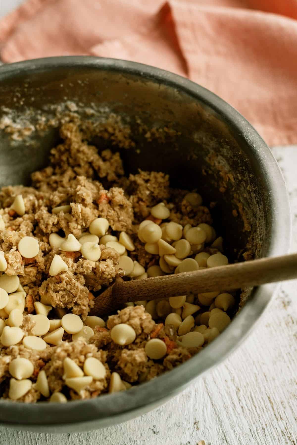 Mixing in white chocolate chips into cookie dough batter