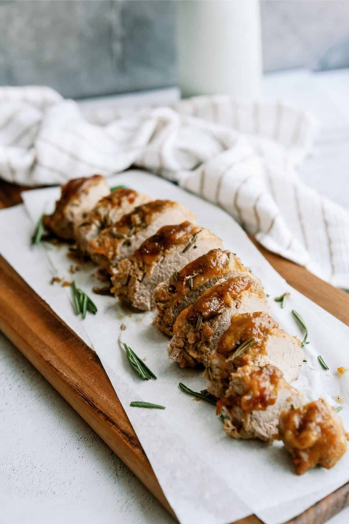 Applesauce Pork Tenderloin sliced on a wooden cutting board