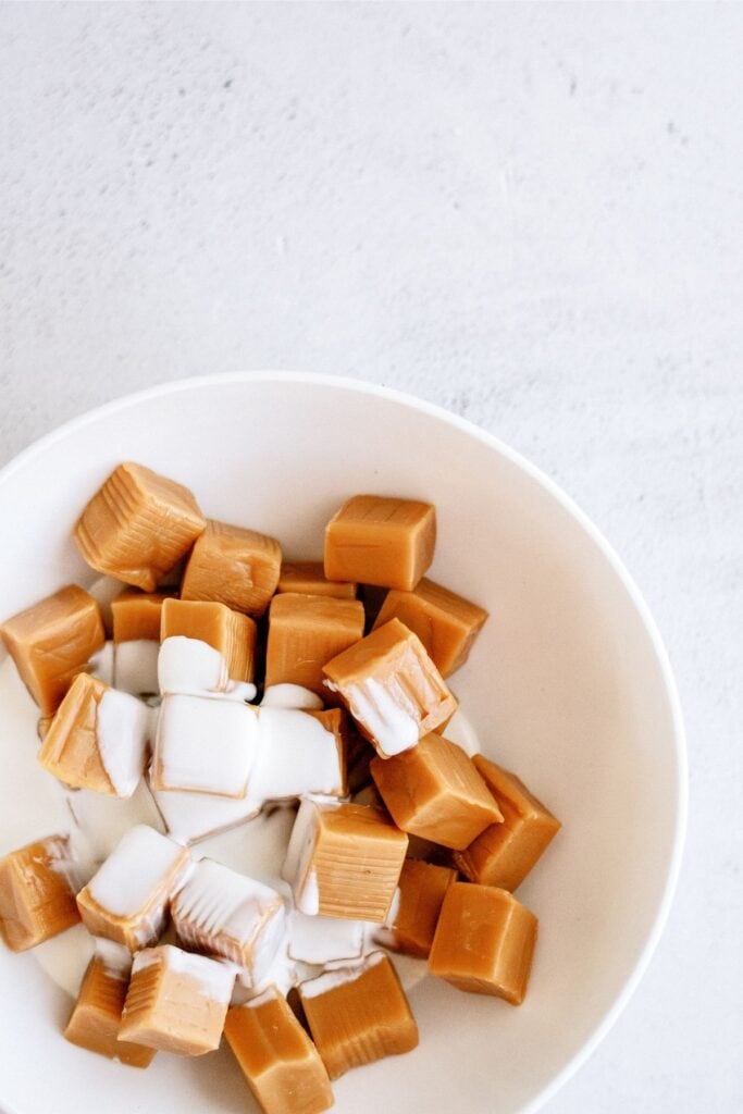 A bowl of caramel cubes with heavy cream poured on top.