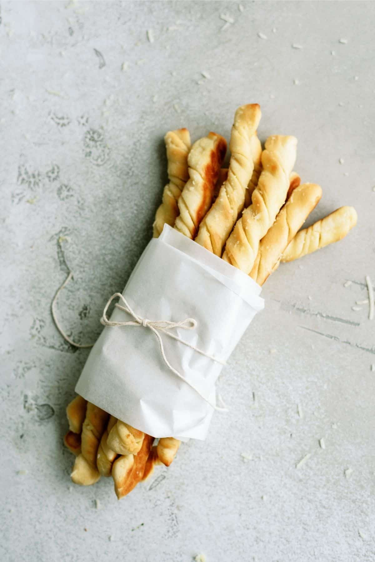 Homemade Pizza Factory Breadsticks wrapped with parchment paper and twine