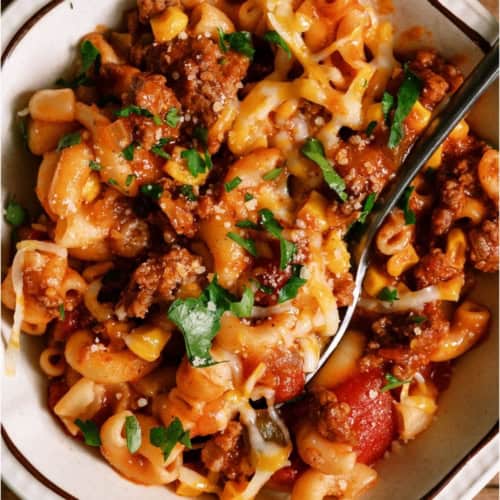 A bowl of Instant Pot Ground Beef Goulash with a spoon.
