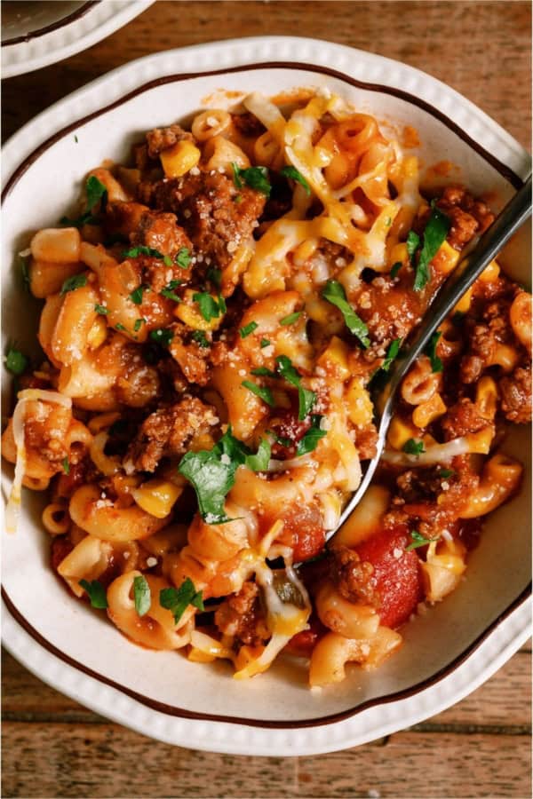 A bowl of Instant Pot Ground Beef Goulash with a spoon.